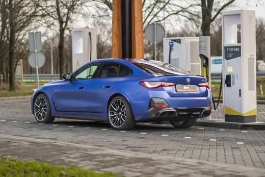 BMW-i4-matblauw-zijkant-achterkant-onderweg-opladen-fastned