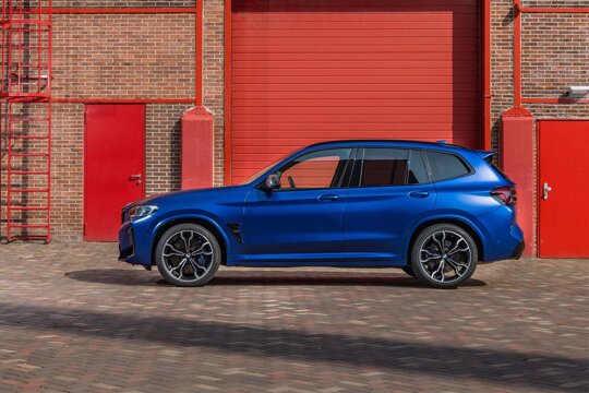 BMW-X3M-Blauw-Zijkant-Rode-Deuren-Muur