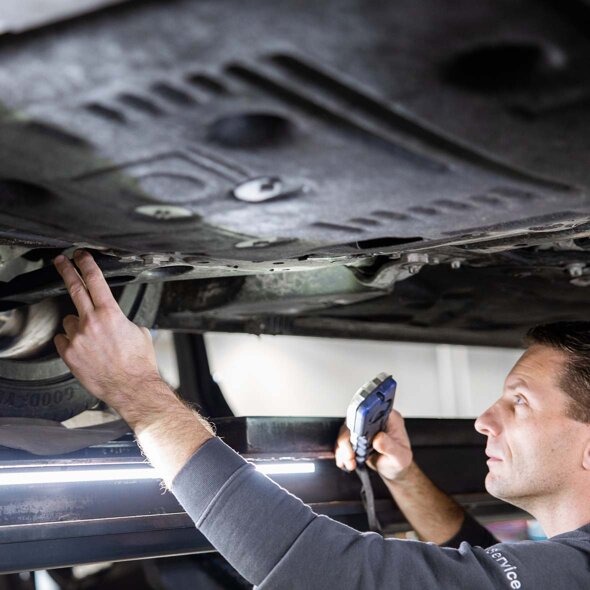 MINI-monteur-aan-het-werk-controle-onderkant-auto-mobiel