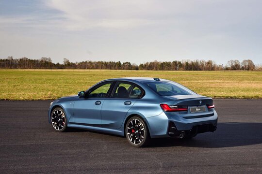 BMW-3-Serie-Sedan-Blauw-Zijkant-Achterkant-Grasveld-Ekris