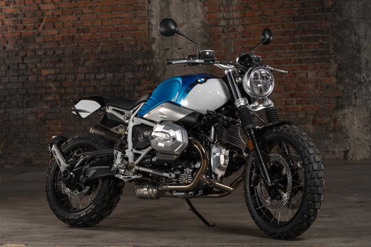 BMW-RnineT-Scrambler-Blauw-Wit-zijkant-bakstenen-muur