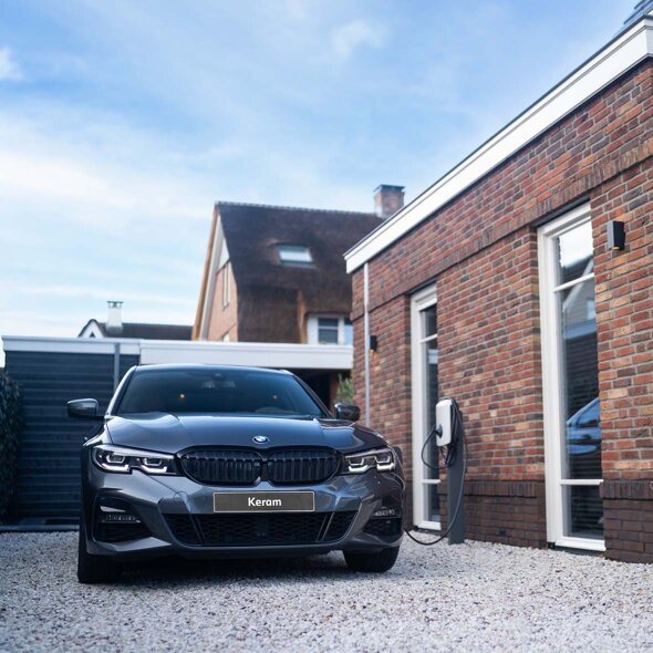 BMW-3-Serie-Sedan-hybride-grijs-voorkant-grindpad-laden-laadpaal-thuis-mobiel-keram