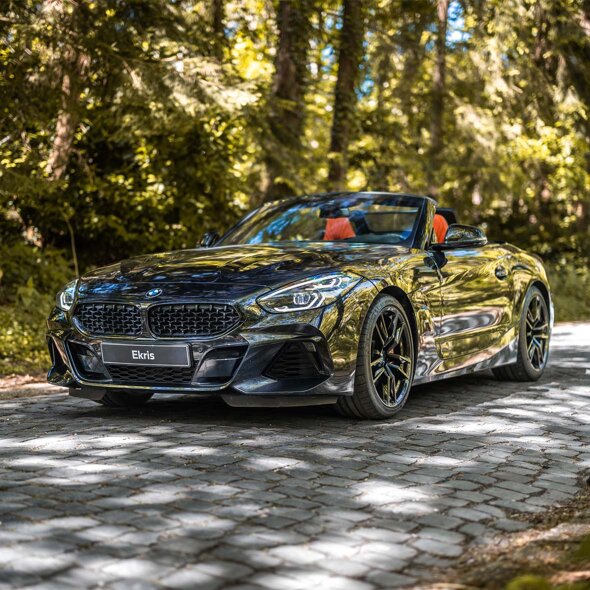 BMW-Z4-zwart-voorkant-klinkers-bos-mobiel