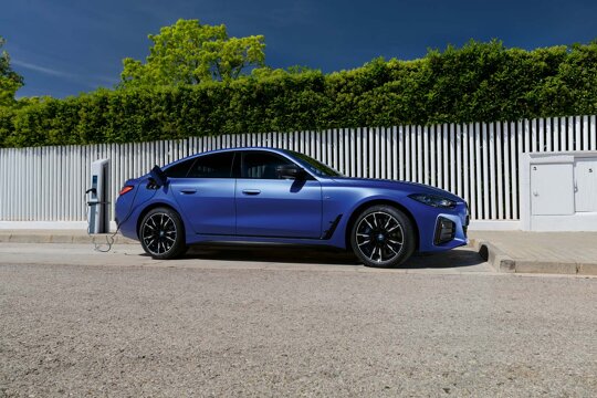 BMW-i4-Blauw-Zijkant-Laadpaal-Heg-Schutting