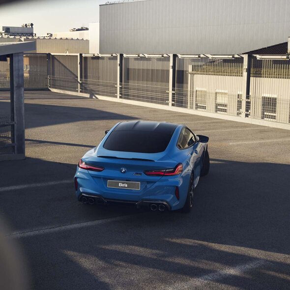 BMW-M8-Blauw-achterkant-bedrijventerrein-mobiel