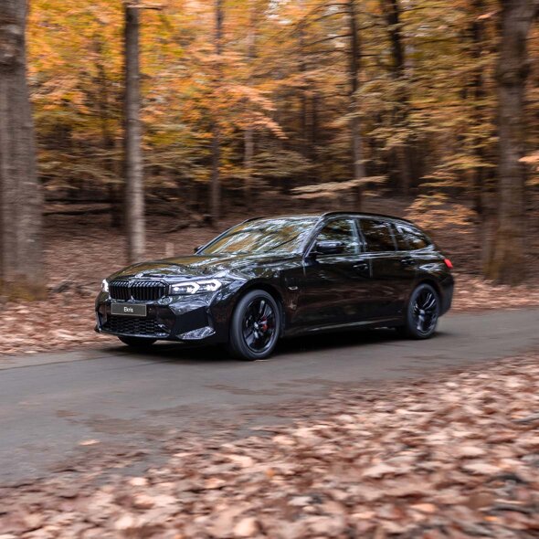 BMW-3-Serie-Touring-Zwart-zijkant-rijdend-bladeren-mobiel