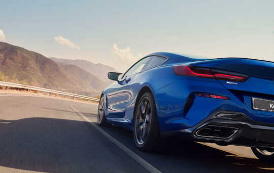 BMW_M8_Coupe_Blauw_Exterieur_Achterkant_Rijdend_Mobiel_Keram