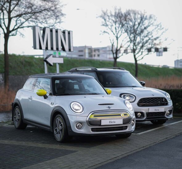 MINI-Electric-Zijkant-MINI-Countryman-hybride-voorkant-grijs-parkeerplaats-MINI-bord-mobiel